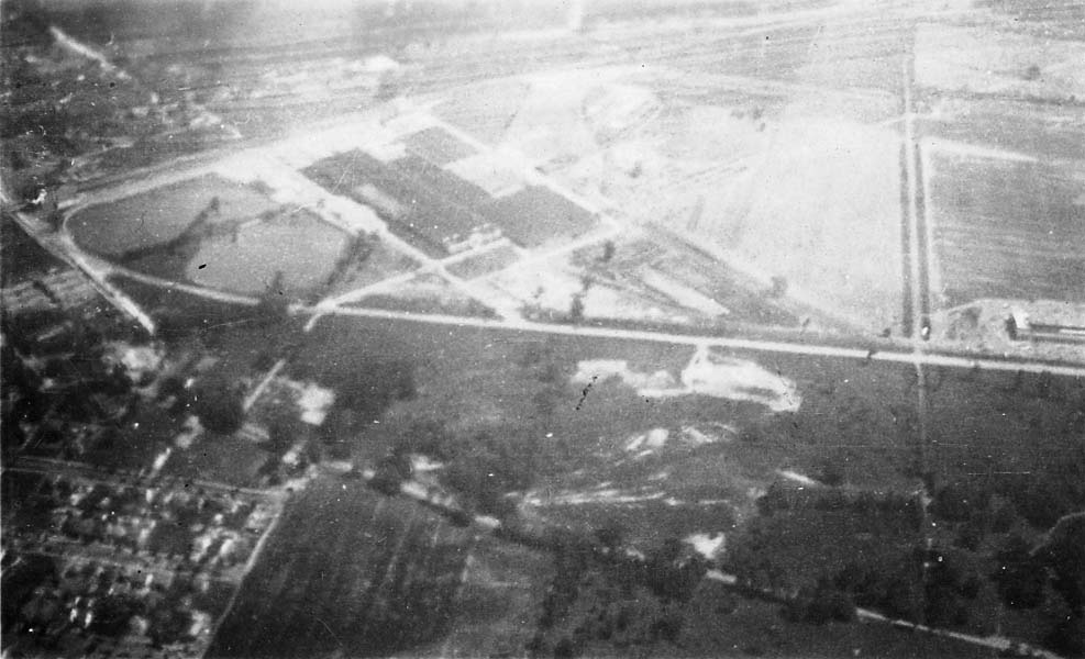 An aerial view showing intersecting roads and large plots of land, captured from a high altitude.