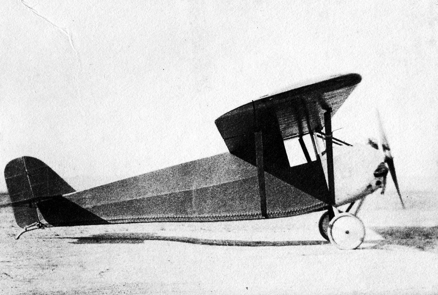 A side profile view of the Driggs-Johnson DJ-1 Bumblebee showing its knife-edge fuselage, enclosed cabin enclosure, and spinning propeller.