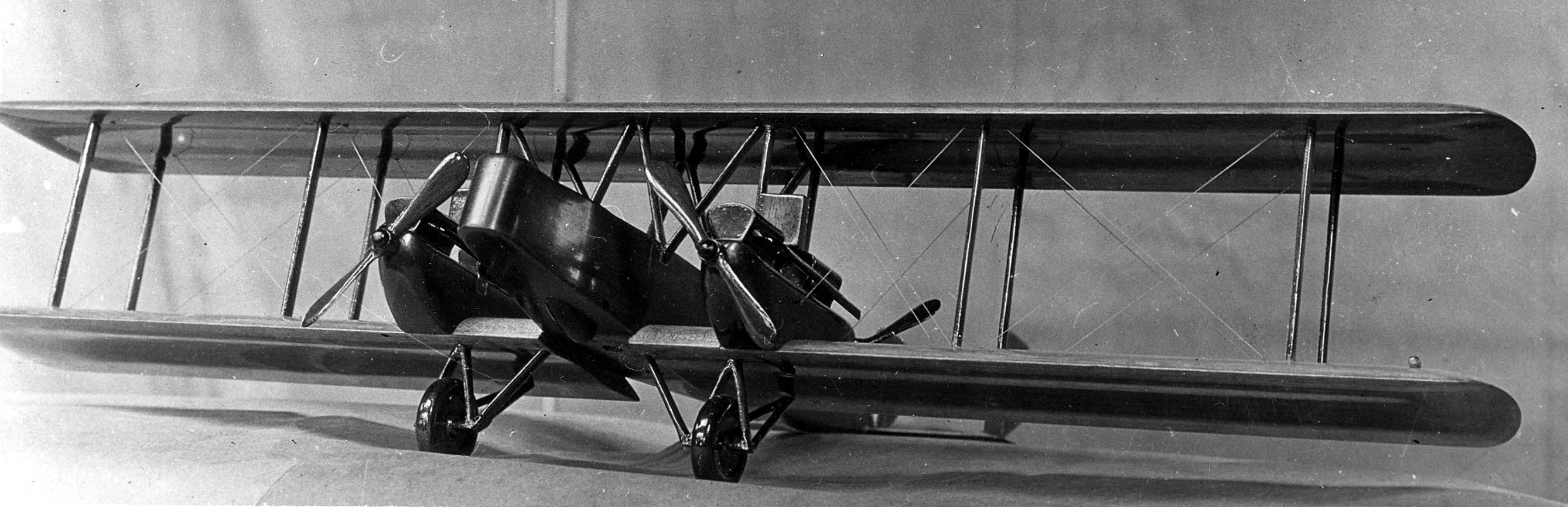 Front three-quarter perspective of the carved wooden Elias XNBS-3 night bomber model showing twin Liberty engines and biplane wings.