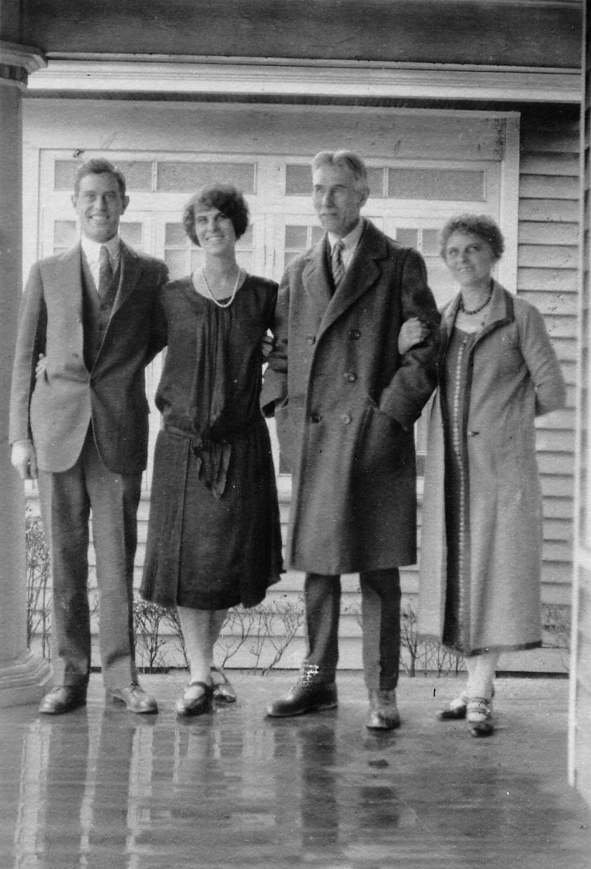 A family portrait of four people standing on a porch: Donald Hall, Alice Hall Smith, Harland Hall, and Louis Hall.