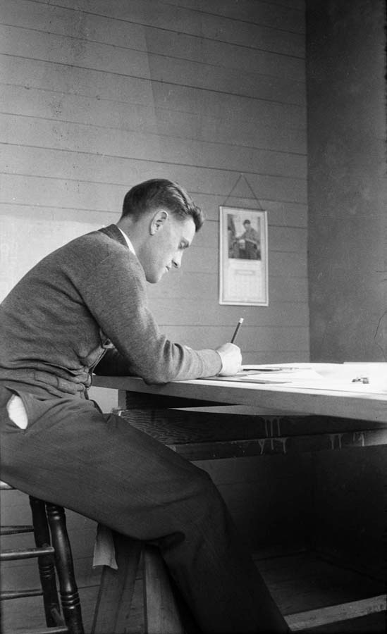 A pristine, iconic side-profile portrait of Donald A. Hall Sr. working intently at his drafting table.