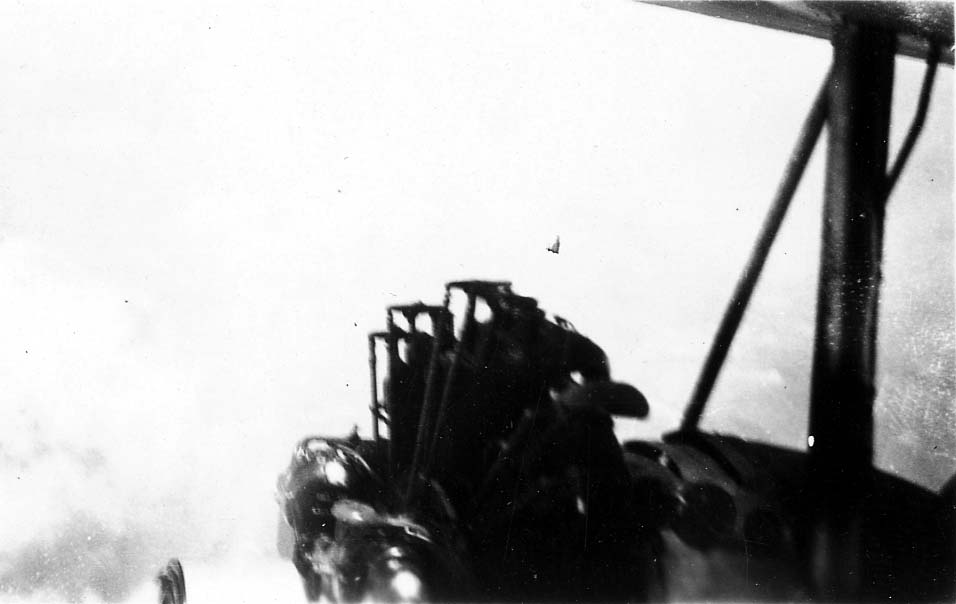 A close, slightly out-of-focus air-to-air view looking directly at the spinning propeller and radial engine block of a Ford Tri-Motor in flight.