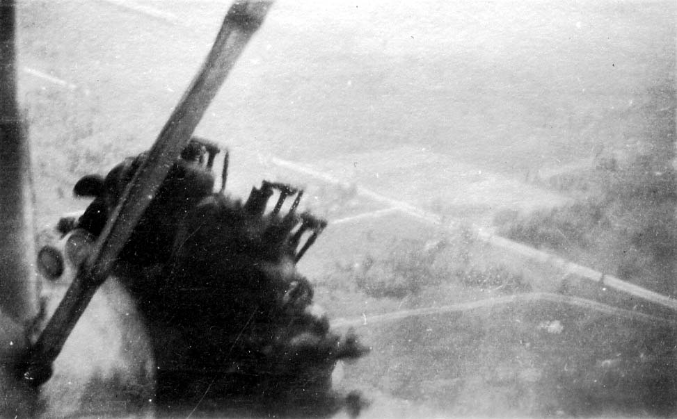 A close air-to-air photograph focusing tightly on the thick, corrugated metal wing and the outboard radial engine of a Ford Tri-Motor in flight.