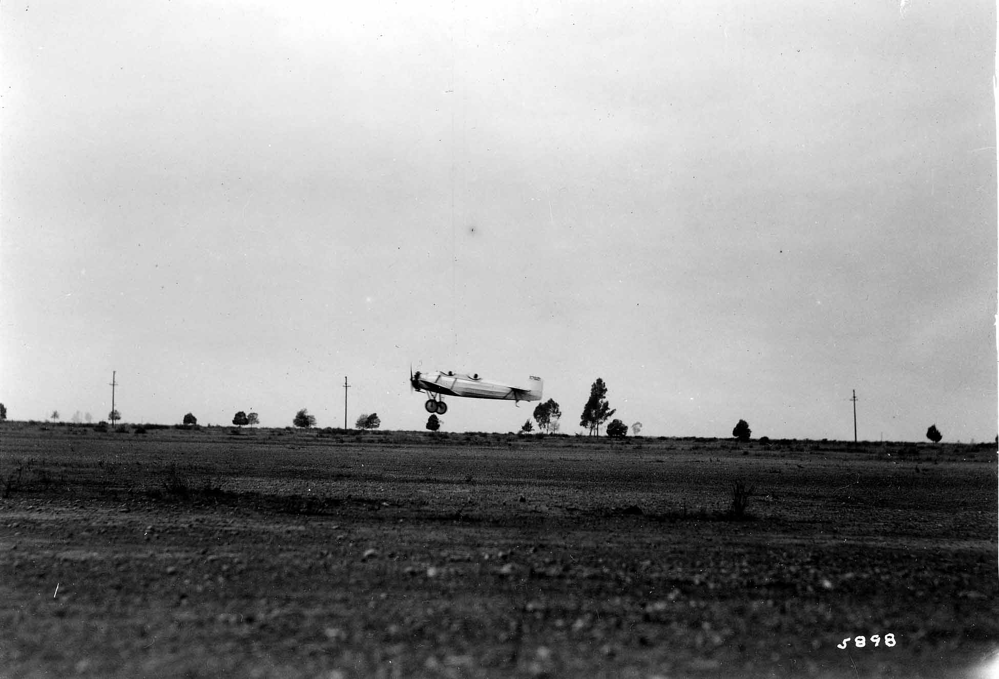 Low-altitude flight photograph plate 5898 showing the Hall X-1 low-wing monoplane airborne during fuel tests.