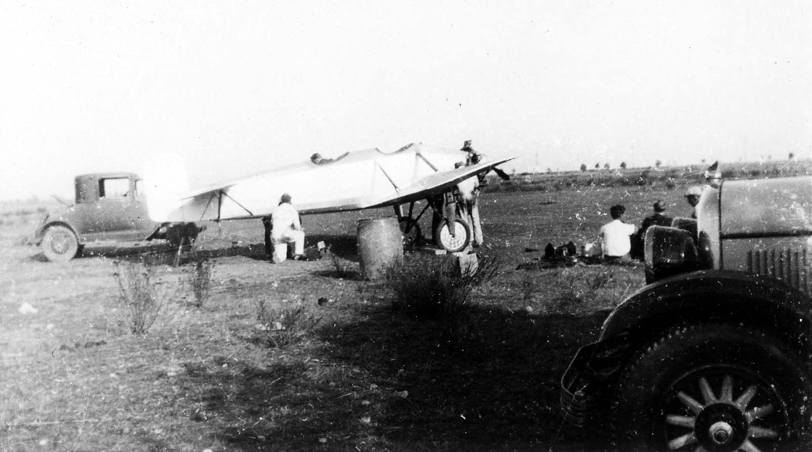 The Hall X-1 tandem-wing prototype parked on the Camp Kearny dirt field beside a support automobile and ground crew in overalls.