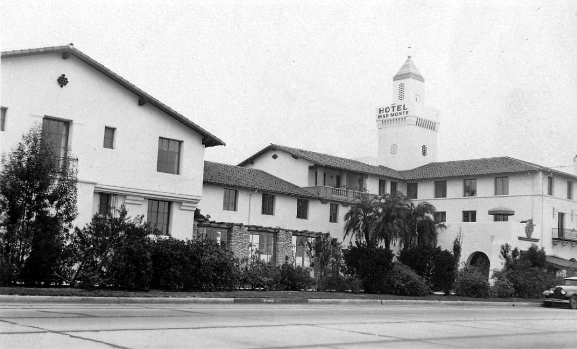 A wide exterior view of the historic Hotel Mar Monte in Santa Barbara, featuring Spanish Colonial Revival architecture and a prominent tower.