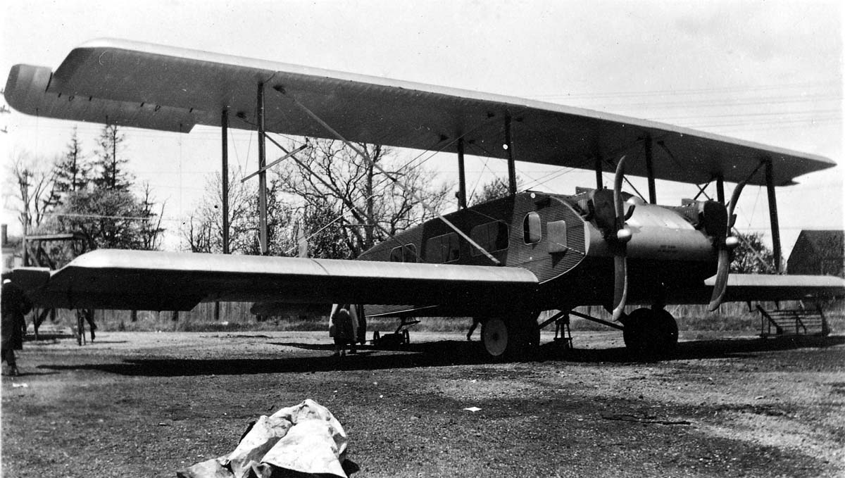 The massive Remington-Burnelli RB-2 twin-engine biplane transport constructed of corrugated duralumin metal skin parked on an airfield.