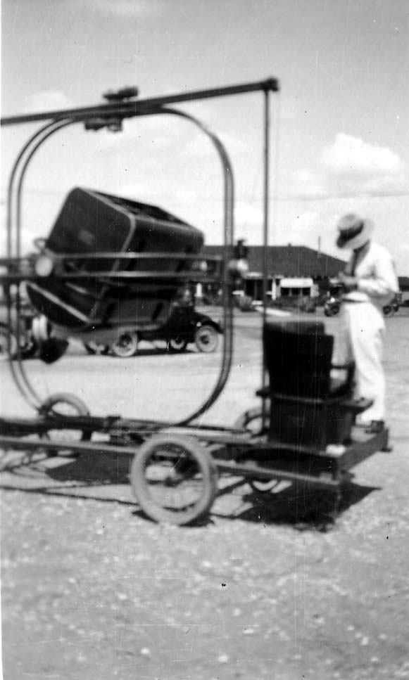 A flight cadet strapped into a Ruggles Orientator, a mechanical ground simulator mounted on a rolling chassis, with an instructor standing nearby.