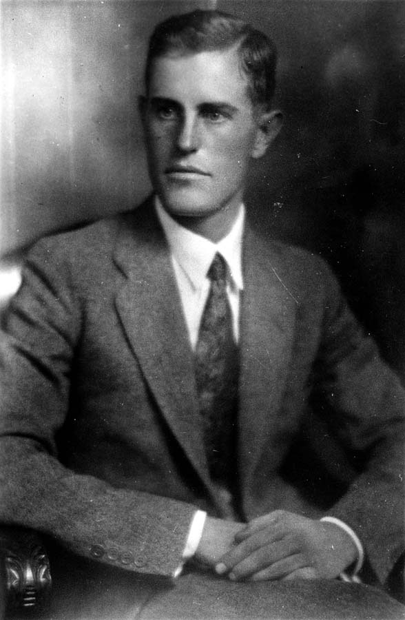 Three-quarter seated studio portrait of Donald A. Hall Sr. in tweed suit with hands clasped.