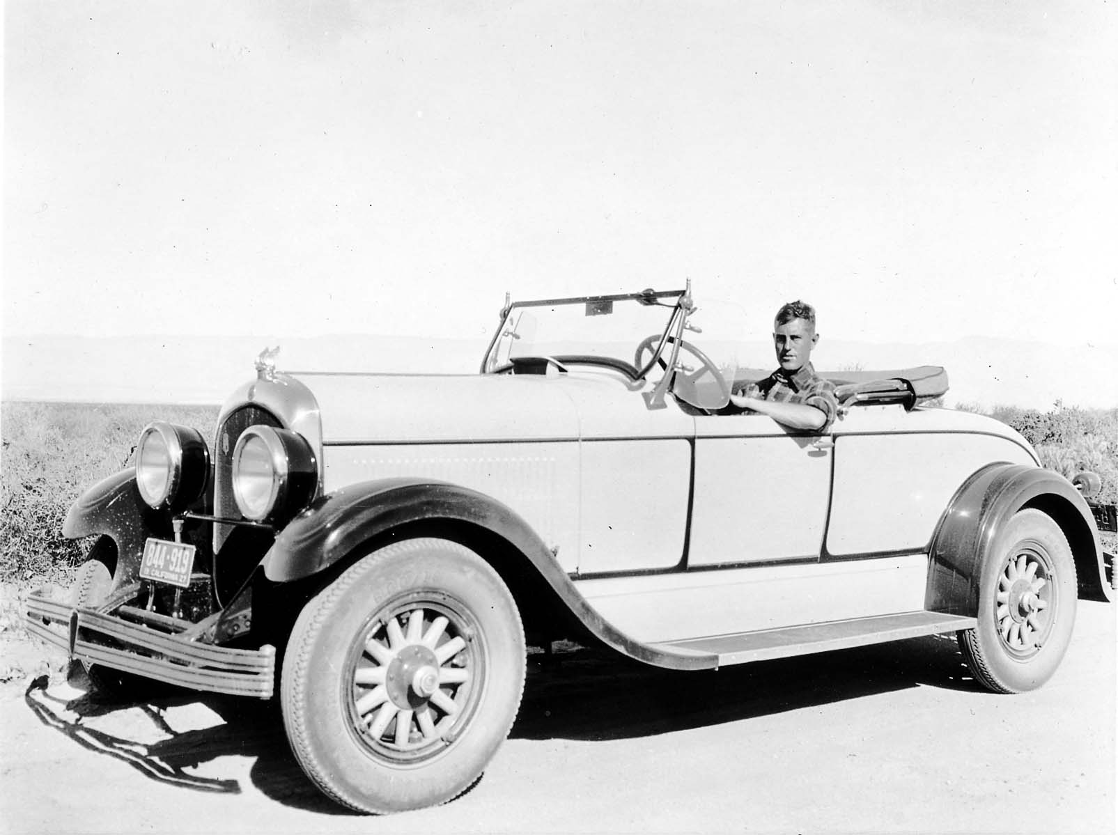 Donald A. Hall Sr. behind the wheel of his 1925 Studebaker Roadster on a dry dirt road with California 1927 license plate 844-919.