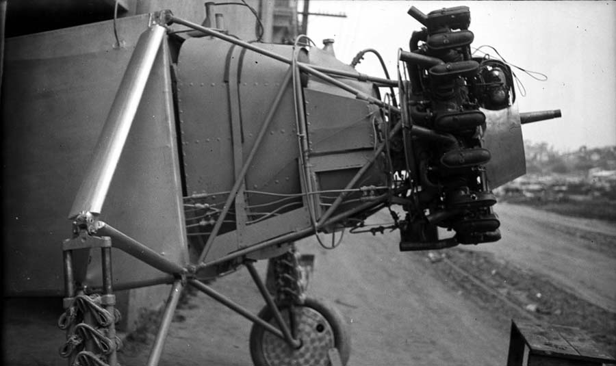 A detailed view of the Spirit of St. Louis engine mount, showcasing the bare cylinders and the strategically placed oil tank acting as a firewall.