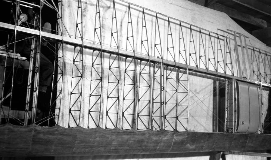 The Spirit of St. Louis wooden wing structure showing the three wing tank bays on the right, with the heeled shoe of a female wing builder visible on the far left.
