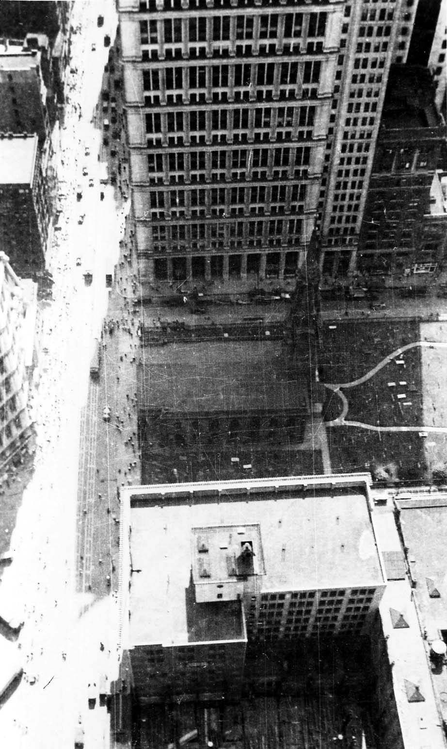 A dizzying downward perspective from the Equitable Building looking straight down at the Gothic spire, roof, and historic burial ground of Trinity Church on Broadway.