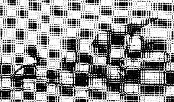 Halftone print of the Spirit of St. Louis on the ground at Camp Kearny with stacked 55-gallon fuel barrels.