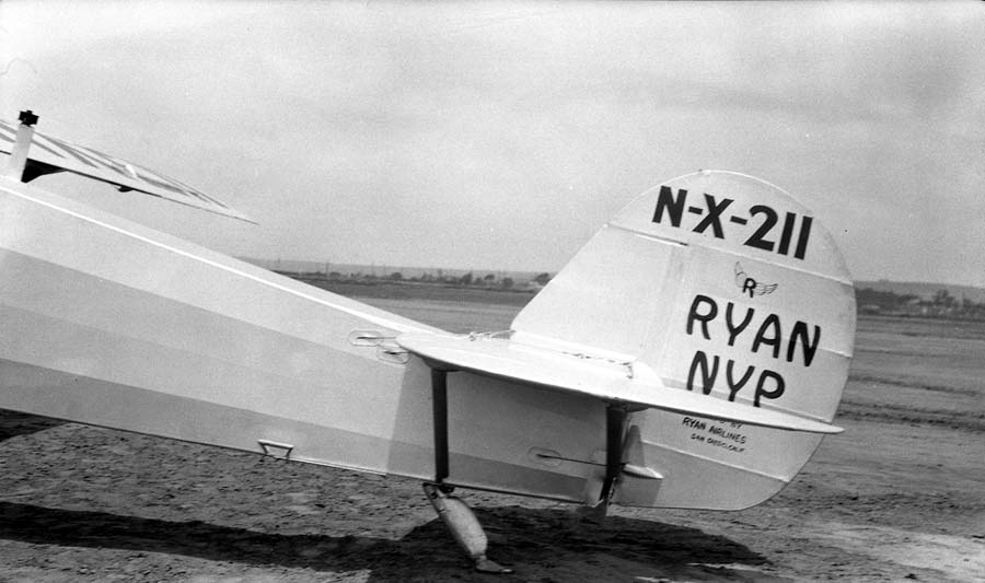 Three-quarter view of the Spirit of St. Louis tail section showing factory rudder stenciling and tail skid housing.