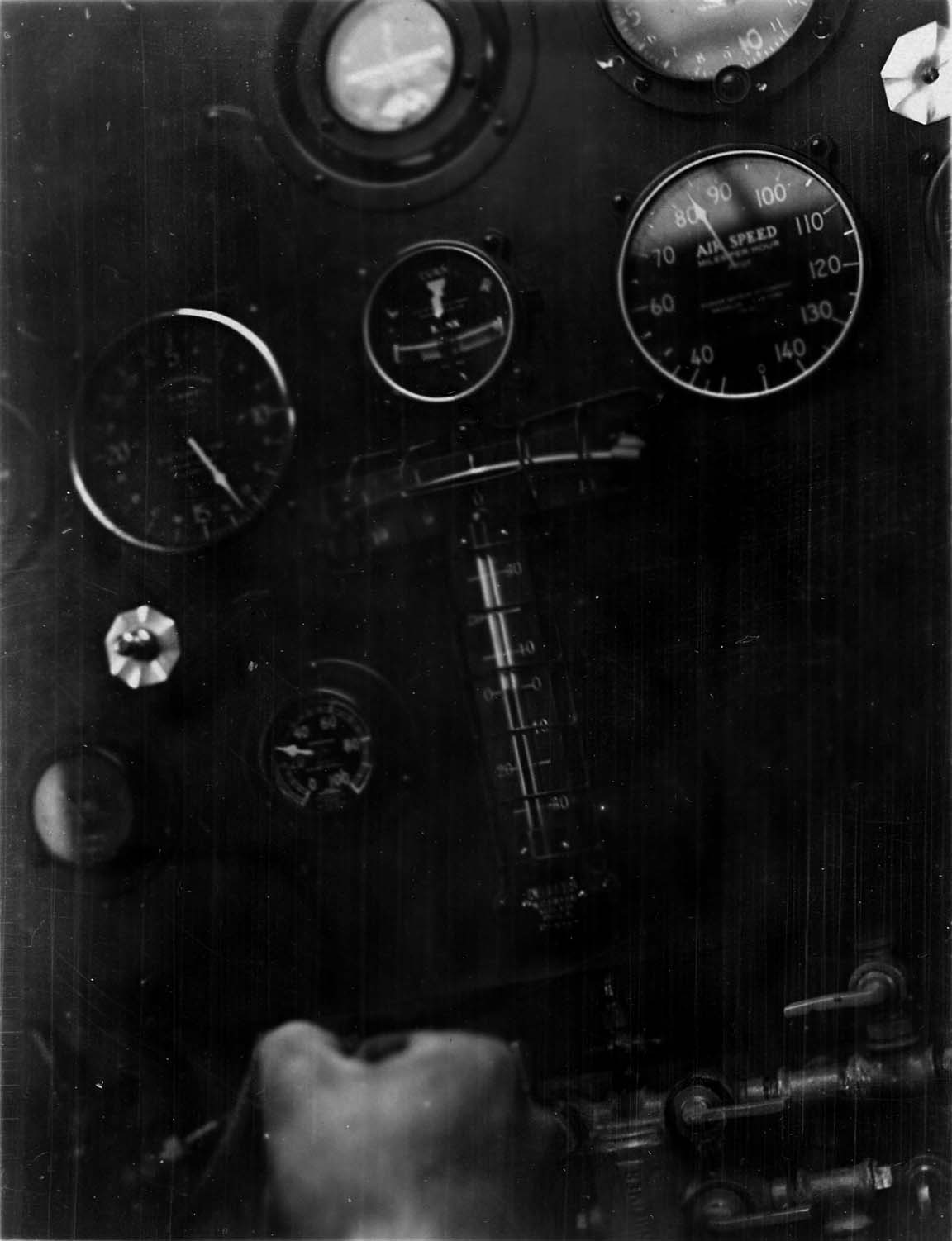 Close-up of cockpit instruments in flight showing airspeed at 98 mph and Lindbergh's gloved hand holding the stick.